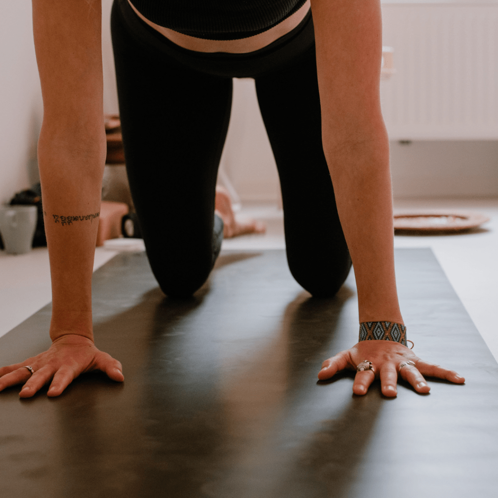 Frau auf Yogamatte im Vierfüßlerstand - Businessyoga und betriebliches Gesundheitsmanagement